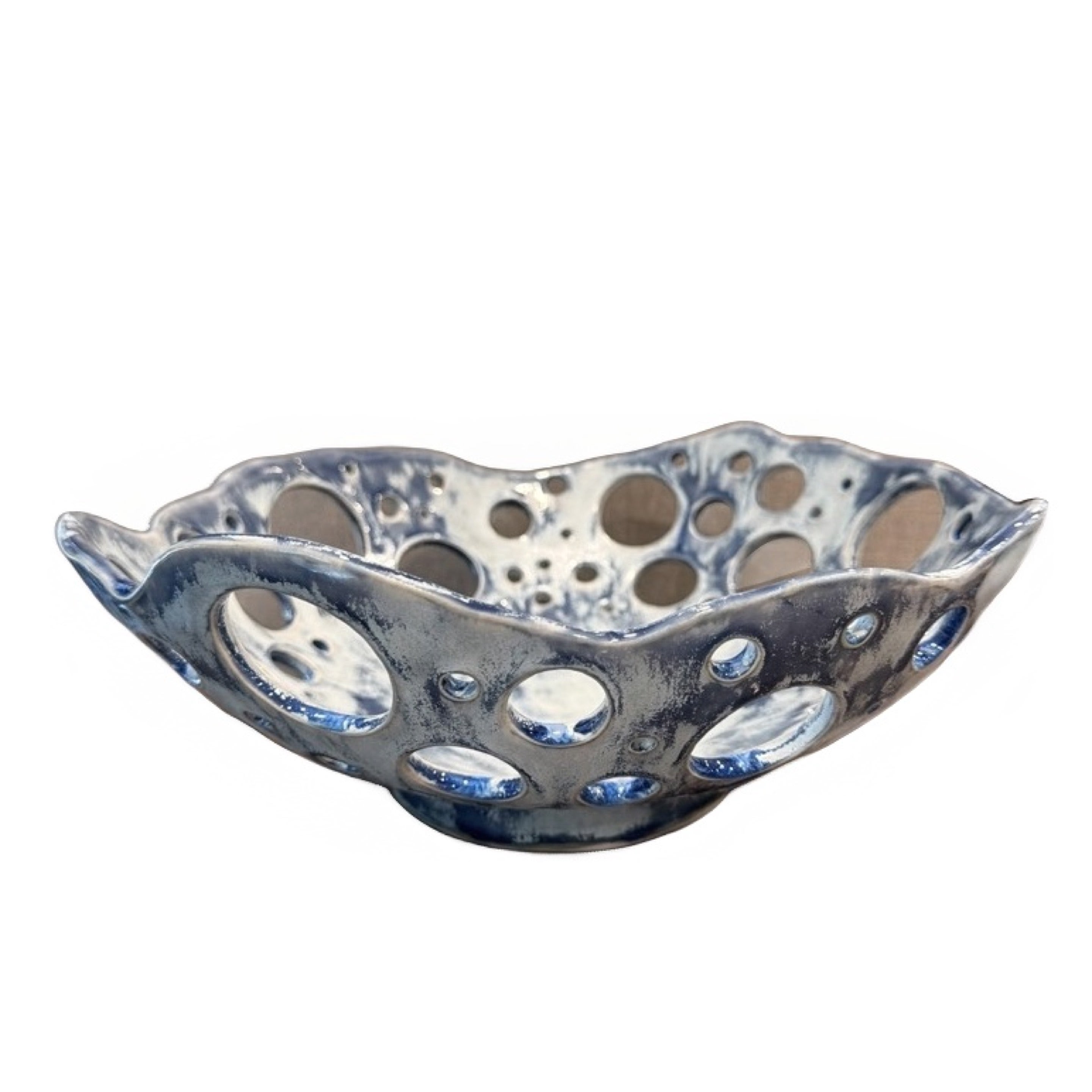 Hand-built bowl with a blue cutout pattern and hand-painted details.