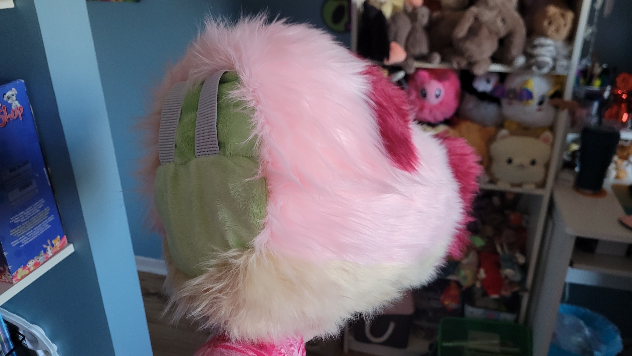 A pink, red and beige fursuit nub tail with a lime green base