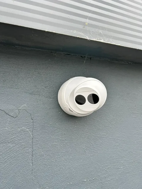 Outdoor PoE security camera being installed by a professional engineer using a drill