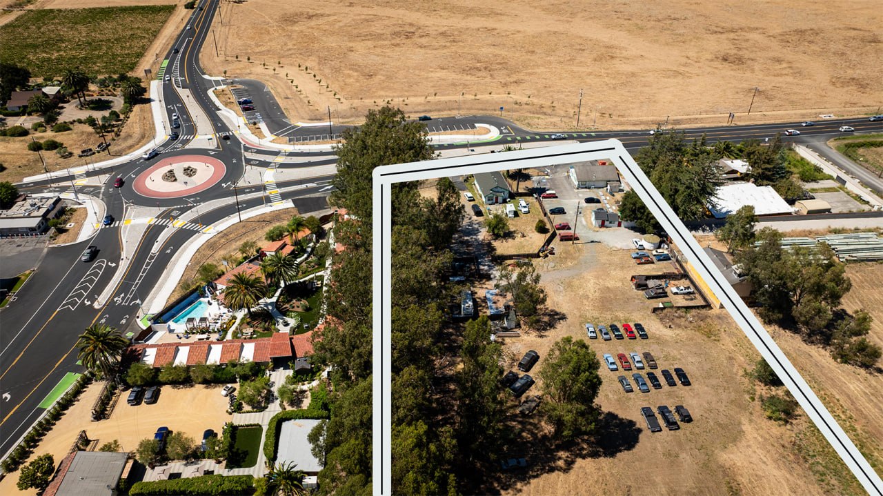 Aerial — full parcel with property boundaries at the gateway roundabout