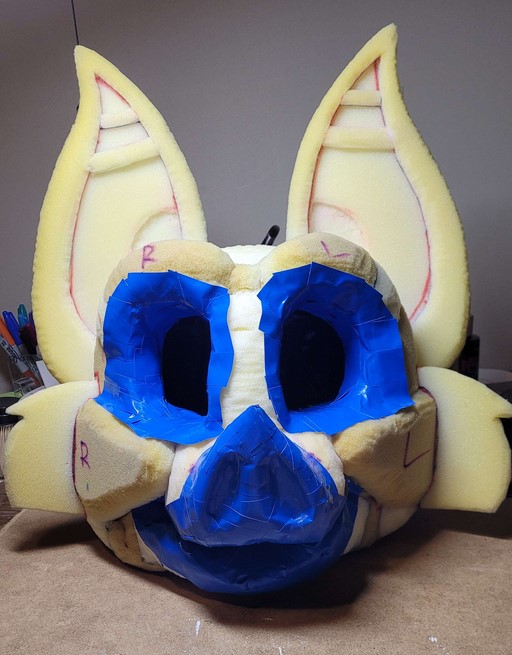 A bat fursuit head foam base that has had the inside of it taped up, including the nose, mouth, and eye rims