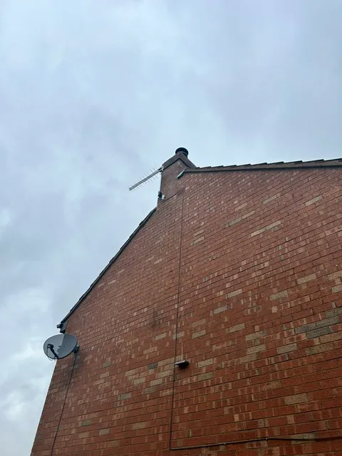 Modern CCTV camera installed on a UK residential property wall overlooking the driveway