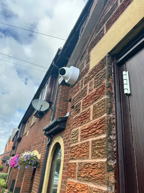 Weatherproof junction box protecting CCTV cable connections on an external wall