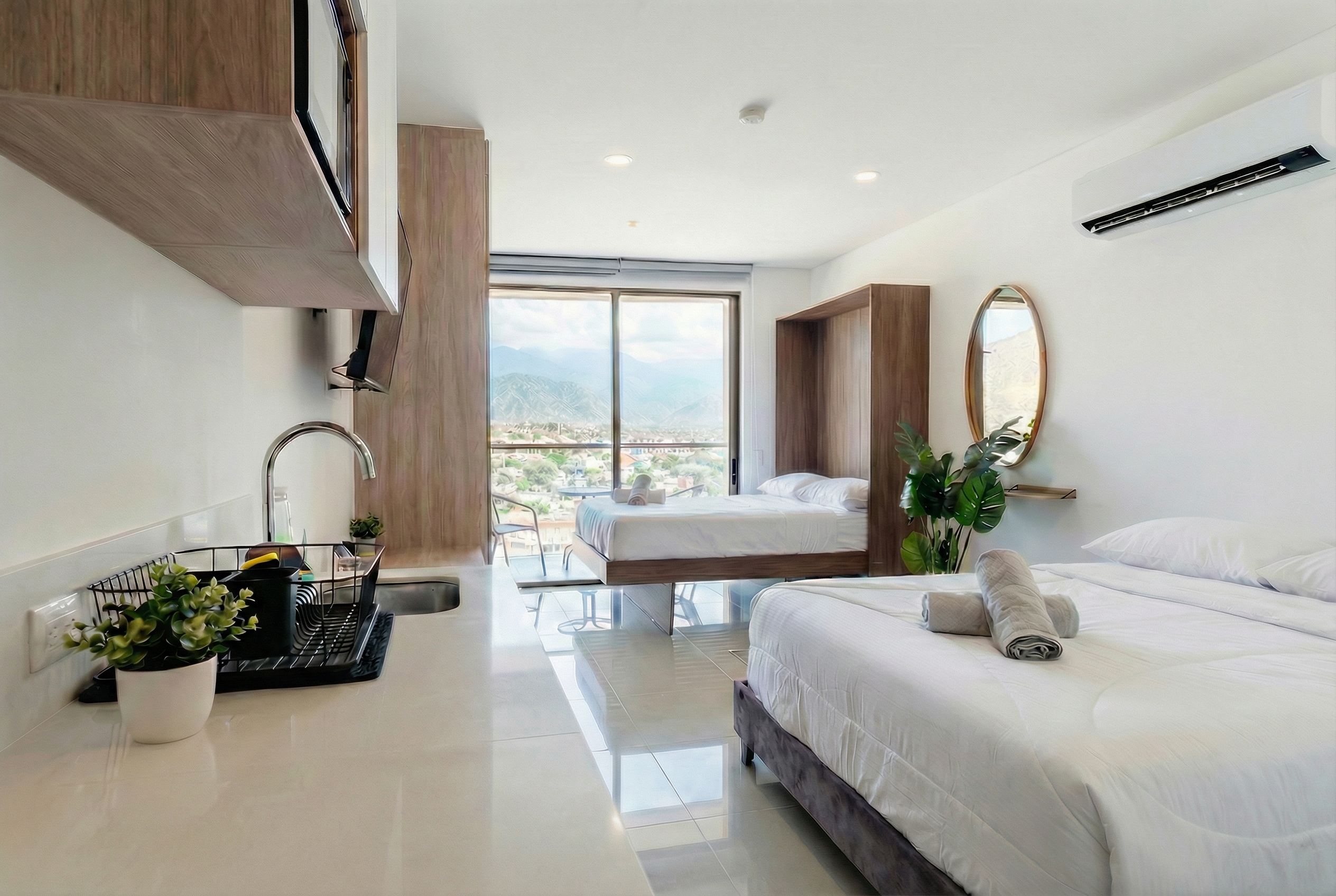 Suite amplia con sala, cocina y dos camas con vista a las montañas